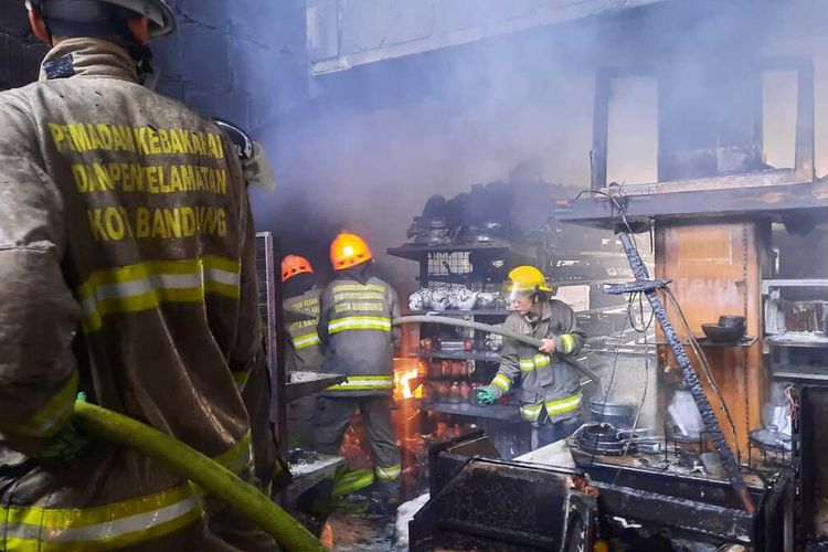 Petugas tengah berupaya memadamkan api di Toko Mutiara Kitchen, Jalan Raya Kopo Kelurahan Situsaer, Kecamatan Bojongloa Kidul, Kota Bandung, Jawa Barat, Minggu (10/4/2022). Gedung berlantai 3 dan basemennya habis dilahap si jago merah, adapun kerugian mencapai Rp 3 miliar.