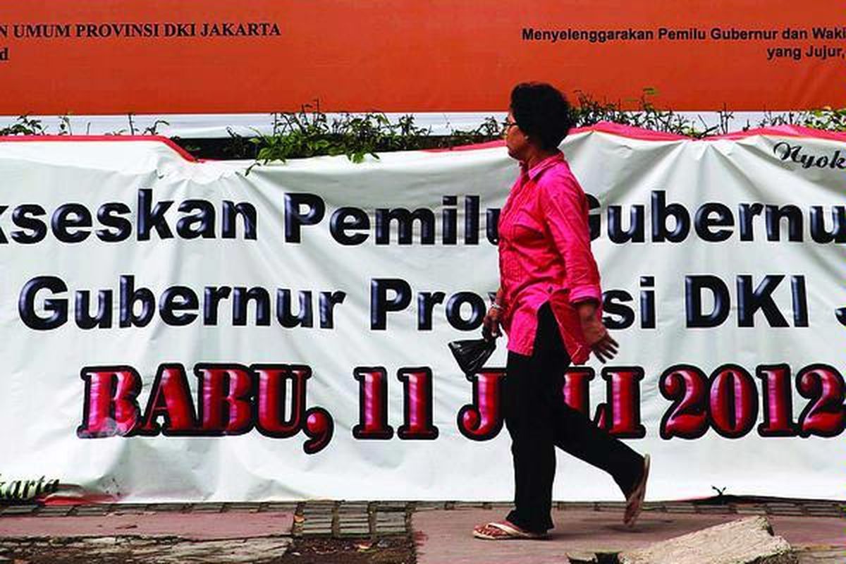 Pejalan kaki melintas di depan baliho besar  Pemilu Kepala Daerah DKI Jakarta di pinggir Jalan Budi Kemulyaan, Jakarta Pusat, Rabu (14/3).