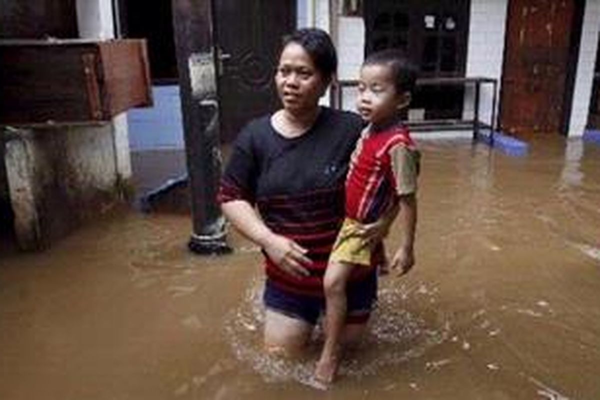 Warga beraktivitas di tengah banjir yang merendam kawasan Kampung Pulo, Jatinegara, Jakarta Timur, Senin (27/2/2012). Hujan deras yang melanda Bogor sejak Minggu menyebabkan Sungai Ciliwung meluap dan merendam ratusan rumah warga yang ada di pinggiran sungai ini. 