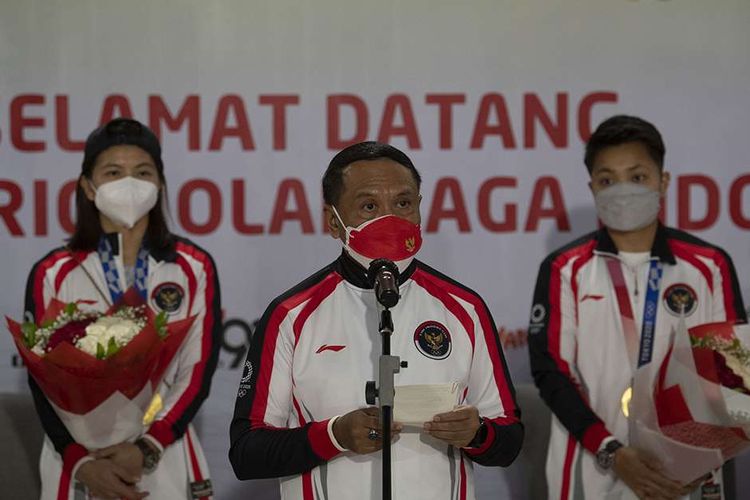 Menpora Zainudin Amali (tengah) memberikan sambutan disaksikan pebulu tangkis ganda putri peraih medali emas Olimpiade Tokyo, Apriyani Rahayu (kanan) dan Greysia Polii (kiri) di Bandara Soekarno Hatta, Tangerang, Banten, Rabu (4/8/2021). Selain Greysia dan Apriyani, pebulu tangkis Anthony Ginting, Praveen Jordan, lifter Rahmat Erwin Abdullah, Nurul Akmal, petembak Vidya Rafika, sprinter Lalu Muhammad Zohri, dan Alvin Tehupeiory juga termasuk dalam kloter terakhir kepulangan kontingen Indonesia dari Olimpiade Tokyo.