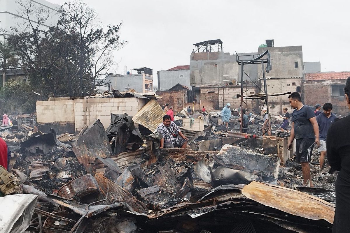 Sekumpulan warga sedang mengumpulkan puing di kawasan Tanah Abang V yang terbakar malam sebelumnya, Senin (27/2/2023). (KOMPAS.com/XENA OLIVIA)