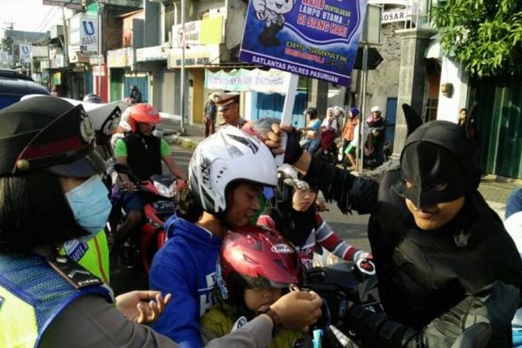 Batman bersama Satlantas Polres Pasuruan sedang memberikan helm pada pengguna jalan pada operasi simpatik 2017