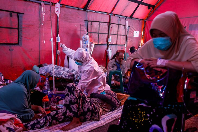 Tenaga medis membantu memasang infus kepada pasien di tenda darurat di depan instalasi gawat darurat (IGD) Rumah Sakit Umum Daerah (RSUD) Chasbullah Abdulmadjid, Kota Bekasi, Jawa Barat, Kamis (24/6/2021). Tenda darurat tersebut dibangun lantaran kapasitas tampung pasien di rumah sakit penuh dan untuk menampung lonjakan pasien Covid-19.