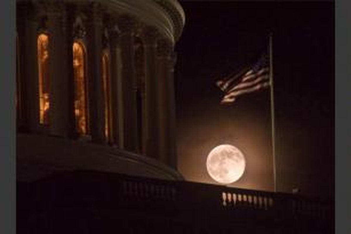 Bulan purnama terbit di belakang US Capitol di Washington, 23 Juni 2013. Bulan yang akan mencapai tahap penuh pada Minggu, 13.5 persen lebih dekat ke bumi dan dikenal sebagai fenomena supermoon.