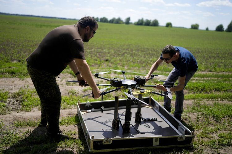Vadym, kiri, dan Oleg memegang drone sebelum mengujinya di pinggiran Kyiv, Ukraina, Rabu, 8 Juni 2022.
