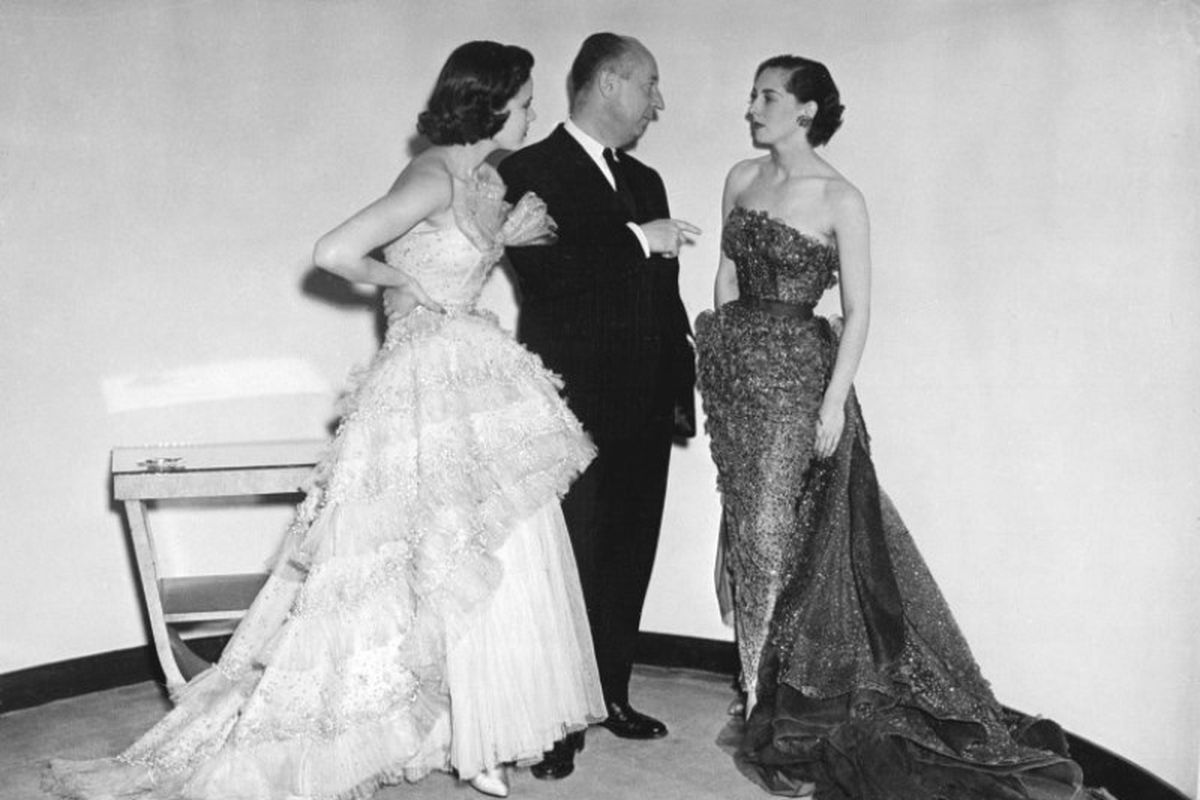 Christian Dior (tengah) bersama dua model yang mengenakan busana rancangannya pada 24 April 1950. (AFP/Pigiste)