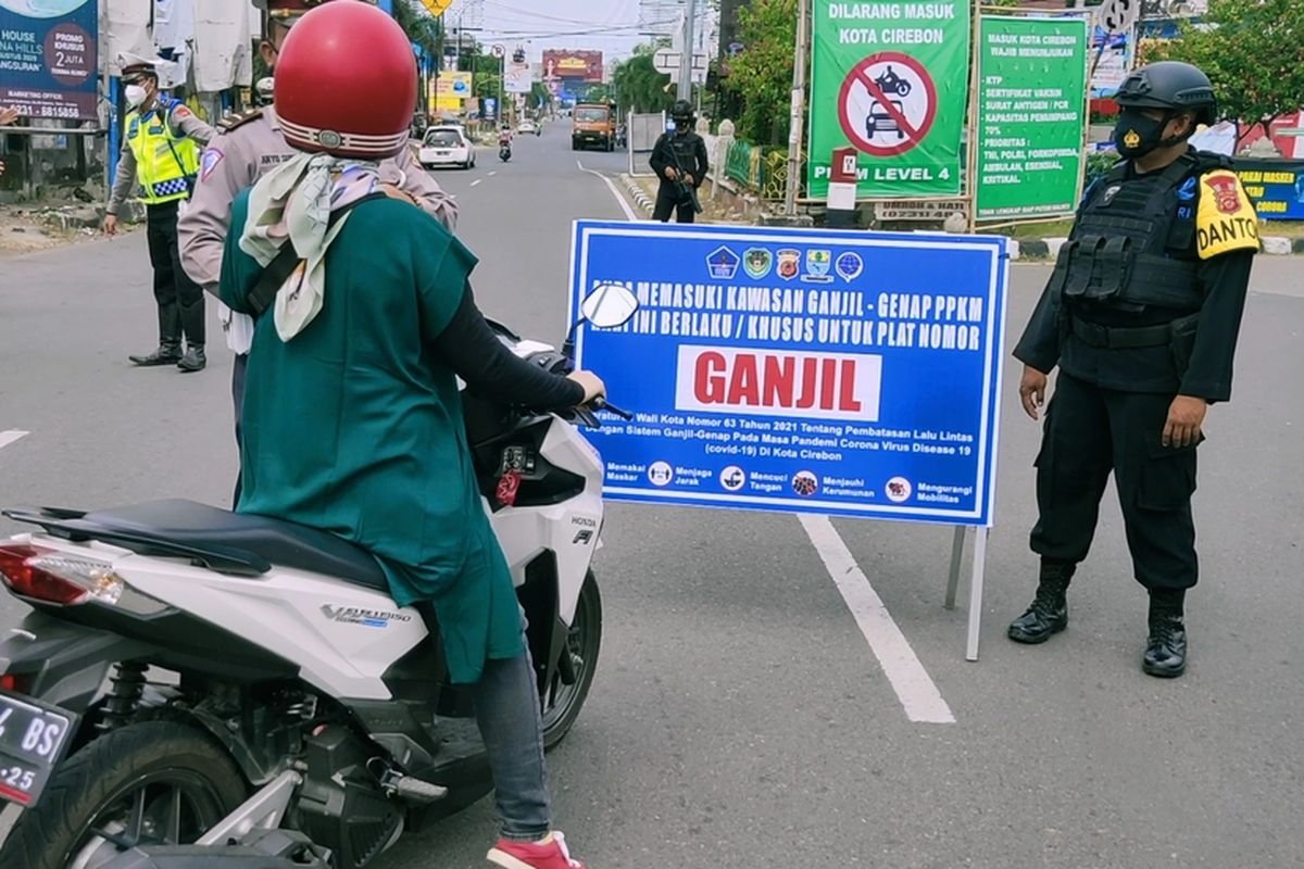 Petugas memberhentikan seorang pengendara sepeda motor yang berplat genap, saat uji coba ganjil - genap di Jalan Tuparev, Cirebon Jumat (13/8/2021). Petugas meminta pengendara putar arah dan tidak boleh masuk ke Kota Cirebon.