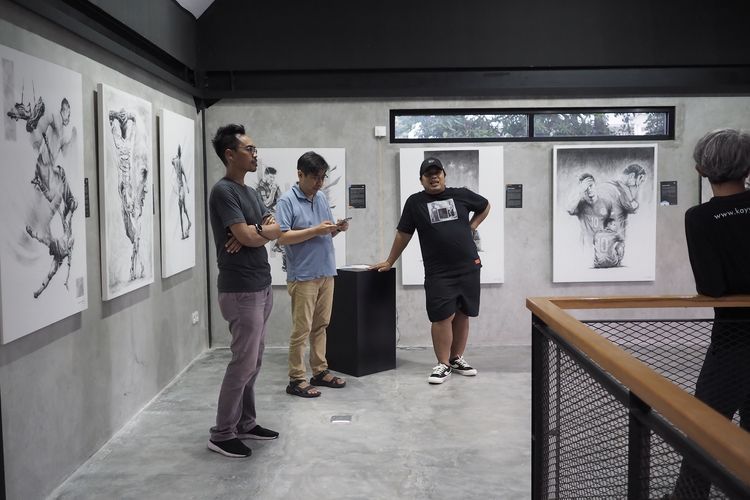 Galih Satrio (kiri), perupa asal Yogyakarta, di pameran tunggal pertamanya bertajuk 11+1 di Garasi Tirtodipuran 17, Yogyakarta, 26 November-4 Desember 2022.