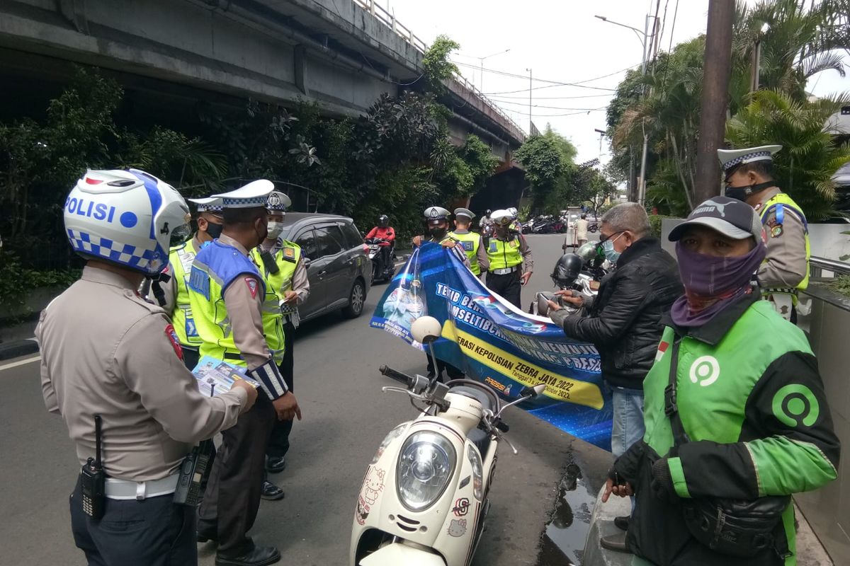 Jajaran Satlantas Polres Metro Jakarta Barat masih melakukan sosialisasi Operasi Zebra Jaya 2022 kepada para pengendara sepeda motor yang melanggar lalu linta di kolong flyover Hotel Peninsula, Jalan Letjen S Parman, Jakarta Barat, Senin (3/10/2022).  
