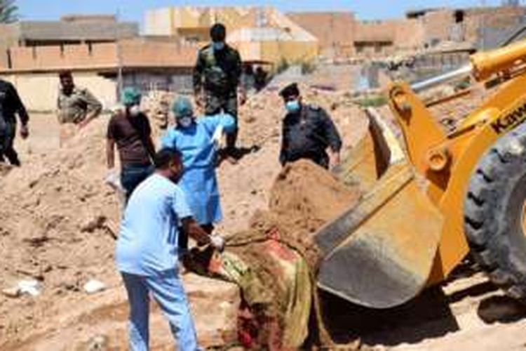 Petugas di Irak bersama tenaga forensik melakukan penggalian di salah satu lokasi kuburan massal yang ditemukan di Ramadi, Irak, pada 19 April 2016.