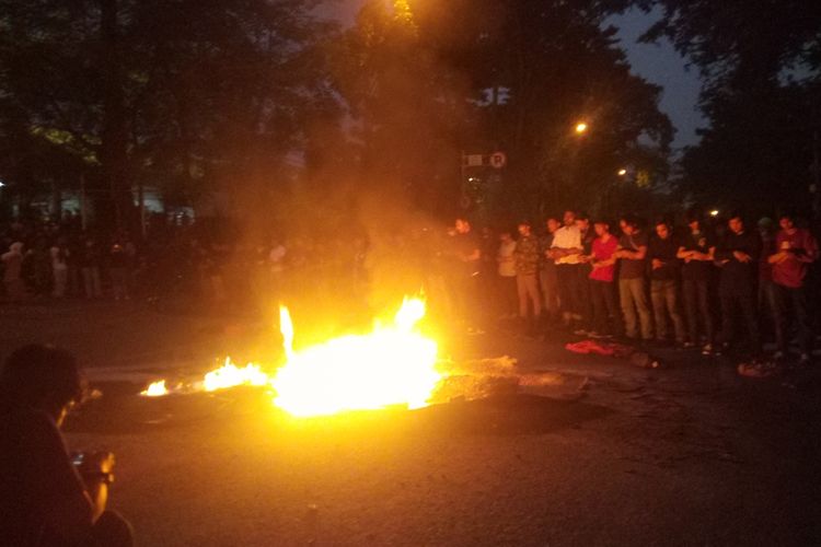 Massa unjuk rasa melakukan shalat magrib berjamaah di sela aksi demo Tolak Revisi UU KPK dan KUHP di Bandung.