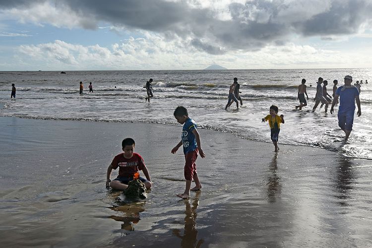 Sejumlah wisatawan memanfaatkan waktu usai berlebaran dengan rekreasi di Pantai Sambolo Anyer, Serang, Banten, Selasa (26/5/2020). Meski Pemda setempat telah menutup semua tempat wisata hingga 3 Juni 2020 untuk mencegah sebaran Covid-19, namun sejumlah pengelola wisata pantai di kawasan Anyer dan Carita tetap menerima pengunjung walau tak seramai libur Lebaran tahun lalu.