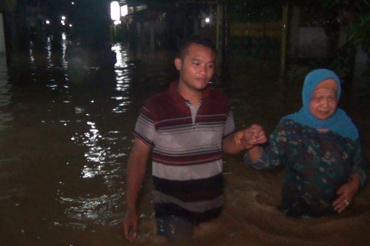 Warga Kelurahan Kelutan, Kecamatan Trenggalek, Kabupaten Trenggalek, Jawa Timur, menyeberangi banjir untuk mengungsi ke tempat yang lebih aman, Kamis (07/03/2019) dini hari. 