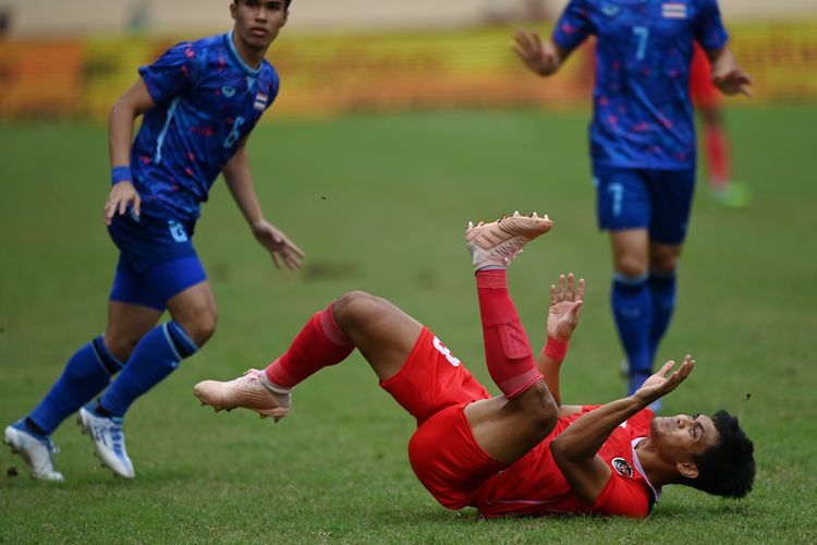 Pesepak bola Timnas Indonesia Rachmat Irianto (kanan) terjatuh usai berebut bola dengan sejumlah pesepak bola Timnas Thailand dalam pertandingan semifinal sepak bola SEA Games 2021 Vietnam di Stadion Thien Truong, Nam Dinh, Vietnam, Kamis (19/5/2022). ANTARA FOTO/Aditya Pradana Putra/tom.