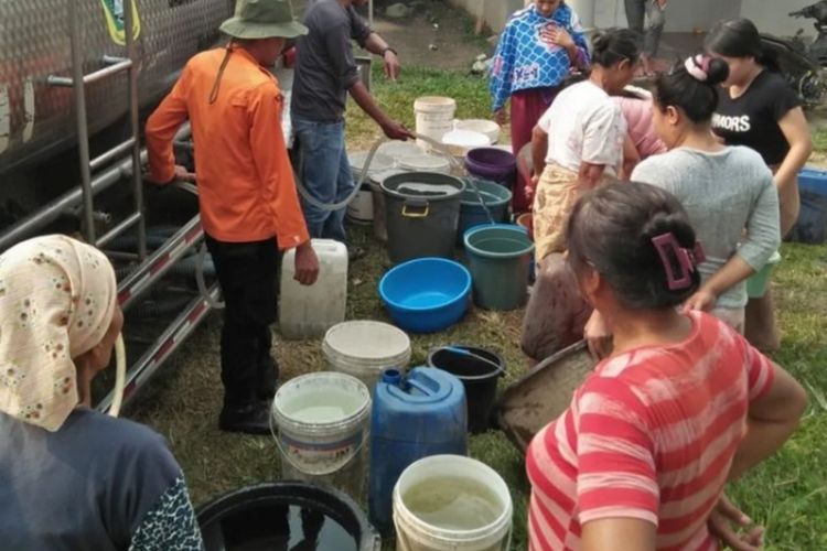 Sejumlah warga mengambil air bersih ke jeriken-jeriken saat truk tangki BPBD mendistribusikan air bersih di Jonggol , Kabupaten Bogor, Jawa Barat, Selasa (22/8/2023).