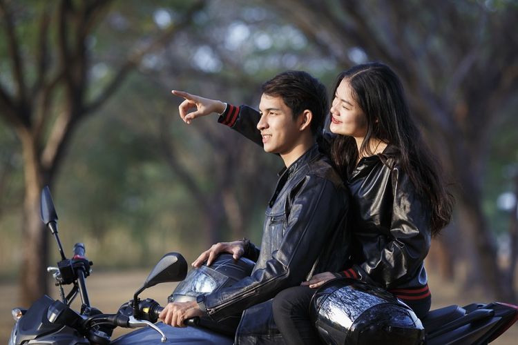 Ilustrasi pasangan berkendara sepeda motor