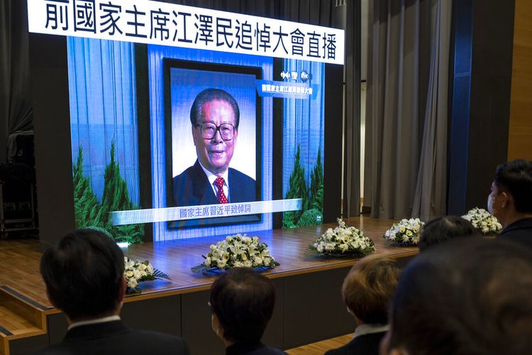 Warga menyaksikan siaran langsung upacara peringatan mendiang Presiden Tiongkok Jiang Zemin di layar di sebuah pusat komunitas di Hong Kong, Selasa, 6 Desember 2022. 