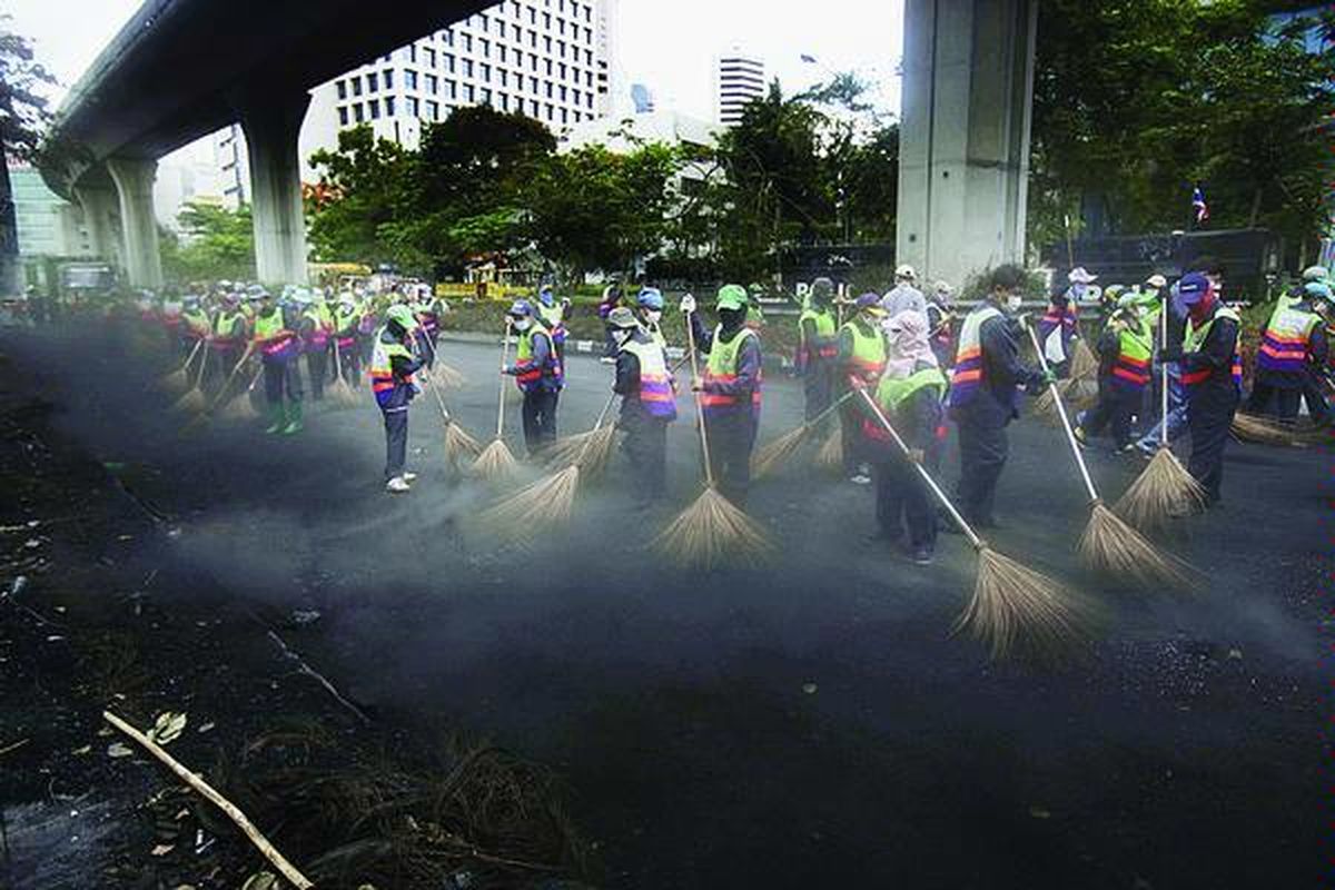 Para pekerja di kota Bangkok membersihkan Lumpini Park, salah satu tempat berkubunya pemrotes anti-Pemerintah Thailand selama dua bulan di jantung kota Bangkok, Jumat (21/5). Meski PM Abhisit Vejjajiva menawarkan rekonsiliasi, tetapi ia tidak menjanjikan diselenggarakannya pemilu dini seperti yang dituntut para pemrotes, para anggota kelompok 