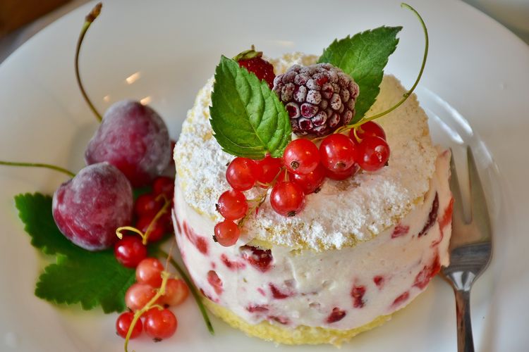 Ilustrasi shortcake dengan whipped cream dan stroberi serta topping buah segar