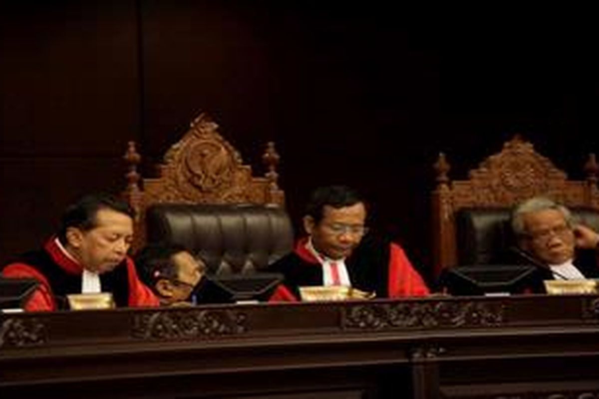 Ketua Mahkamah Konstitusi, Mahfud MD (tengah) bersama anggota majelis hakim, Achmad Sodiki (kiri) dan Harjono membacakan putusan uji materil tentang undang-undang minyak dan gas bumi di Mahkamah Konstitusi, Jakarta, Selasa (13/11/2012). Mahkamah Konstitusi memutuskan pasal yang mengatur tugas dan fungsi Badan Pelaksana Minyak dan Gas Bumi (BP Migas) yang diatur dalam UU Nomor 22 Tahun 2001 tentang Minyak dan Gas Bumi bertentangan dengan UUD 1945 dan tidak memiliki hukum mengikat.  