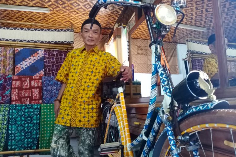 Agus, pemilik Gerai Batik SHD (SahaDeui) bersama sepeda ontel tua miliknya yang dihiasi cat airbrush motif batik garutan yang dipajang digerainya.