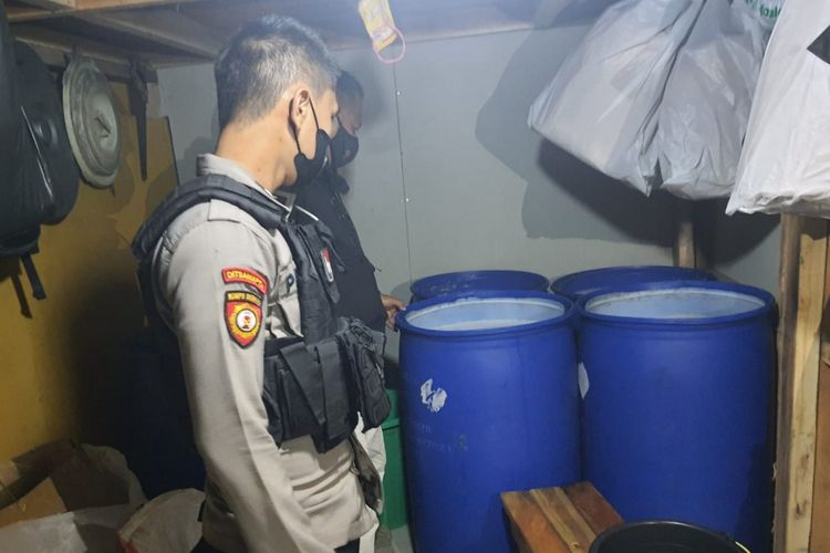 Polisi menunjukkan mobil boks berisi ratusan botol miras dan ribuan liter tuak dalam drum di Mako Polresta Tasikmalaya, Rabu (20/4/2022) malam.