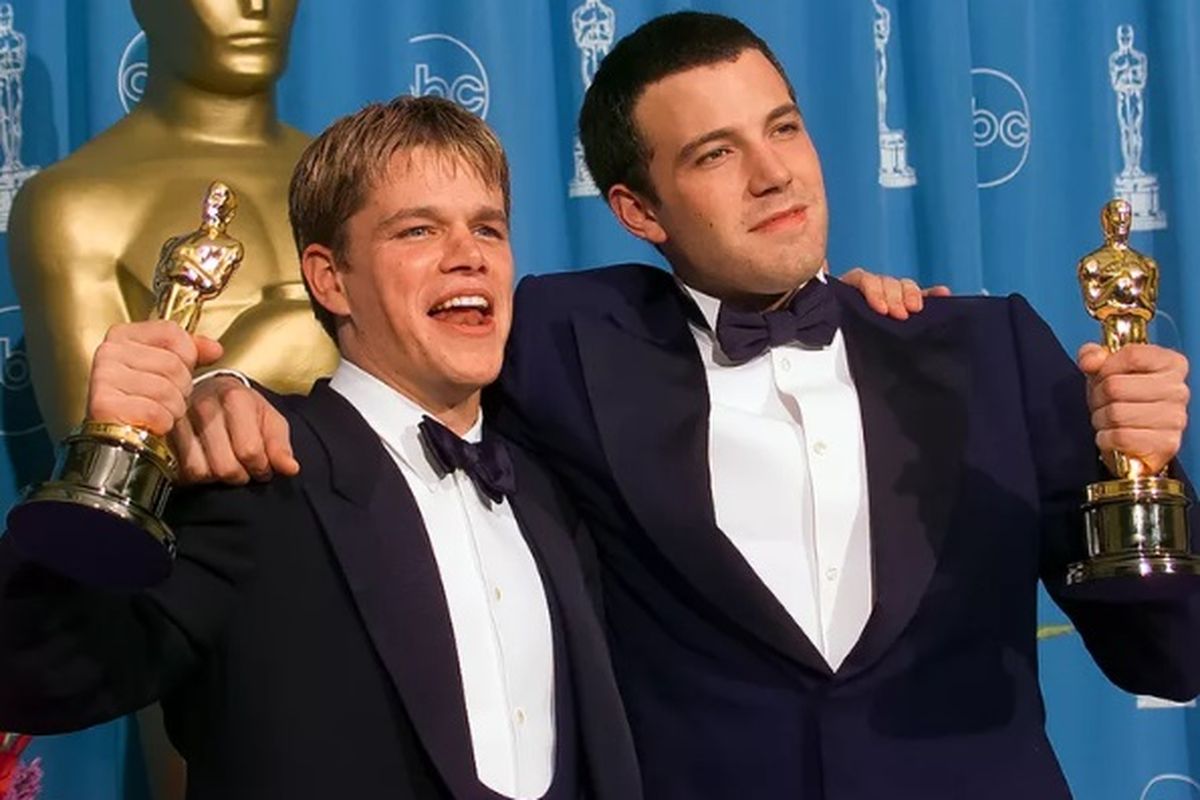 Aktor Matt Damon (kiri) dan aktor Ben Affleck usai memenangkan piala Oscar bersama.