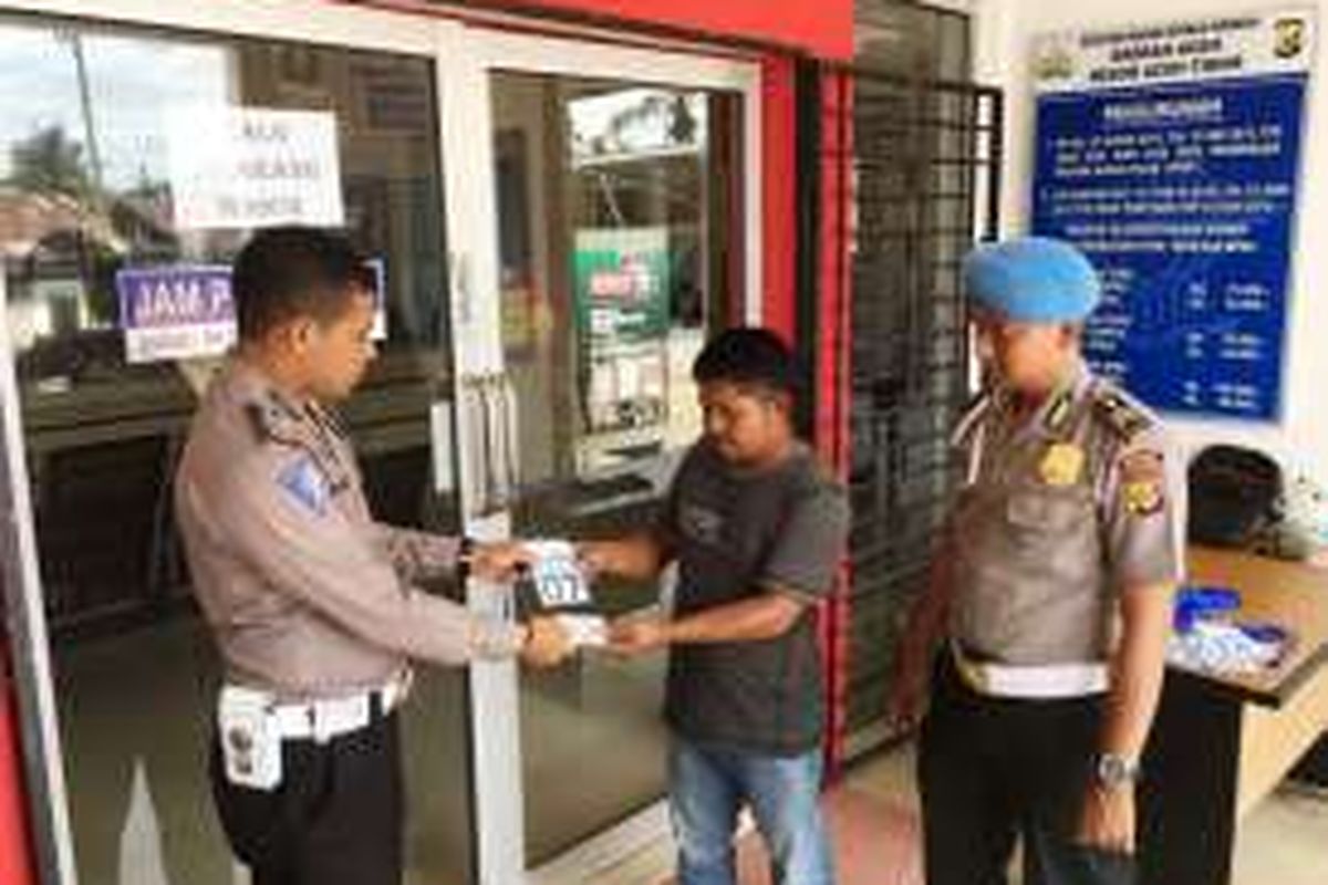 Warga menerima kartu pengunjung untuk membuat surat izin mengemudi dengan diawasi personel Propam di Mapolres Aceh Timur, Sabtu (15/10/2016)