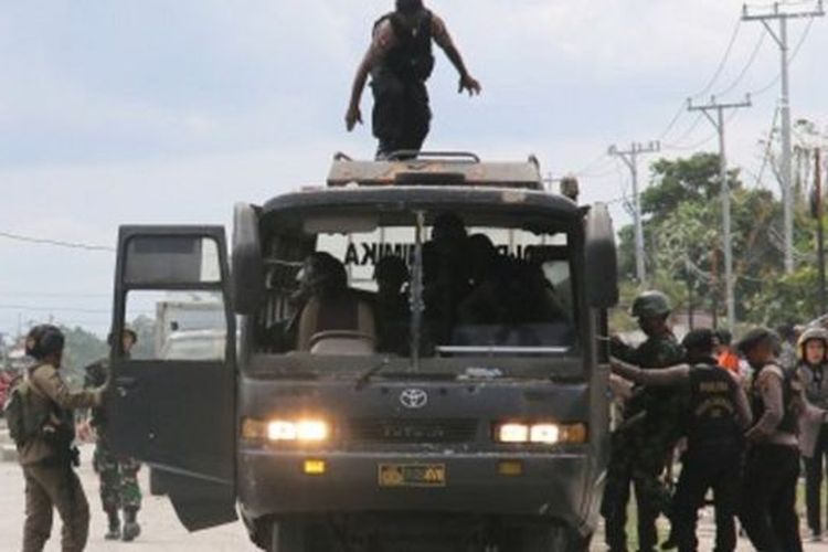 Petugas kepolisian dan TNI melakukan pengamanan saat terjadi aksi protes di Mimika, Papua, Rabu (21/08). 