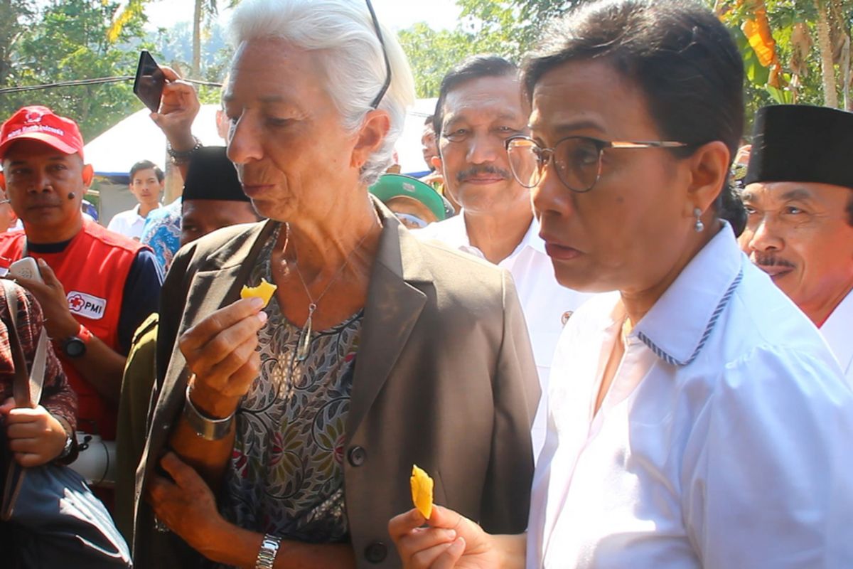 Direktur IMF Chistine Lagarde bersama Menteri Keuangan Sri Mulyani mencicipi ubi goreng  yang masih hangat, yang dijual korban gempa Lombok, di Desa Guntur Macan, Lombok Barat, Senin (8/10/2018).
