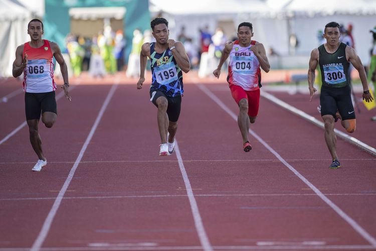 Pelari Nusa Tenggara Barat Lalu Mohammad Zohri (kedua kiri) berlari paling depan dalam final nomor lari 100 meter putra PON XX Papua di Stadion Atletik Mimika Sport Center, Kabupaten Mimika, Papua, Rabu (6/10/2021). Lalu Mohammad Zohri meraih medali emas sementara pelari Nusa Tenggara Barat lainnya Sudirman Hadi meraih medali perak dan pelari Kalimantan Tengah Eko Rimbawan meraih medali perunggu.