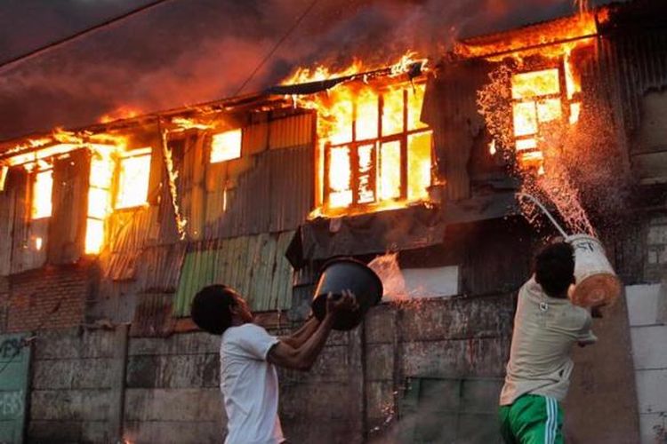 Warga berusaha memadamkan api dengan alat seadanya pada kebakaran yang melalap pemukiman di Kampung Duri Selatan, Tambora, Jakarta Barat, Kamis (7/2/2013). Akibat besarnya api puluhan rumah yang berada di tepi rel kereta itu habis terbakar.