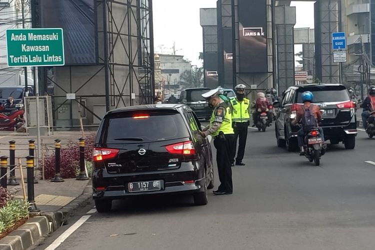 Polisi menilang sejumlah mobil yang melanggar aturan ganjil genap di Jalan RS Fatmawati, Cilandak, Jakarta Selatan pada Kamis (28/10/2021).