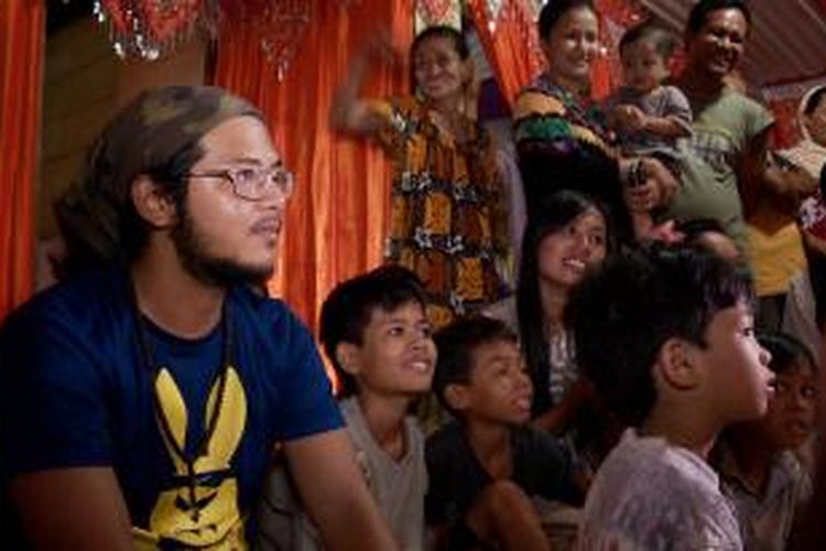 Pemandu Acara 100 Hari Keliling Indonesia, Ramon Y Tungka menonton pernikahan warga melalui televisi kabel di Majene, Sulawesi Barat