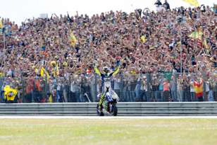 Pebalap Movistar Yamaha asal Belanda, Valentino Rossi, merayakan kemenangan di depan pendukungnya setelah finis di urutan pertama balapan GP Belanda di Sirkuit Assen, Sabtu (27/6/2016).