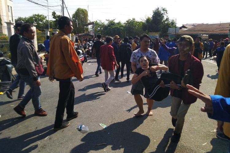 Mahasiswa yang jatuh kelelahan digotong oleh mahasiswa lain menuju mobil Ambulans di Jalan Tengkawang Samarinda, Senin (30/9/2019).