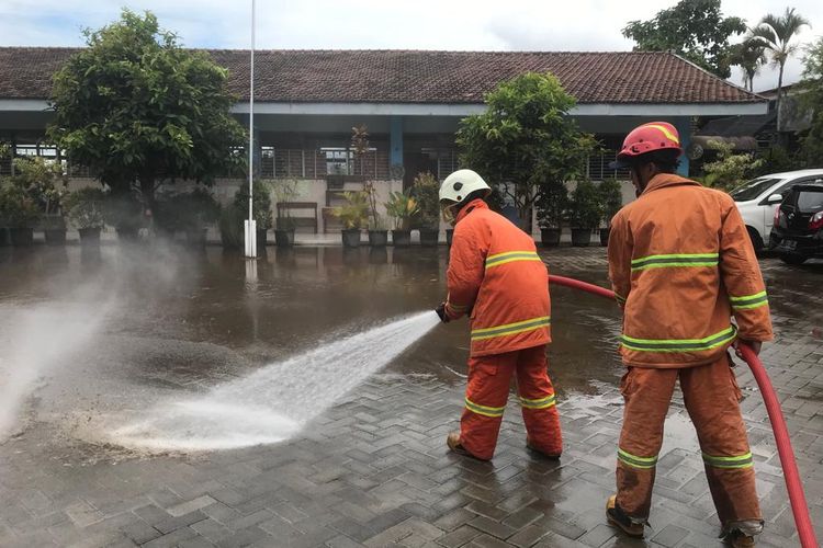 Petugas gabungan dari BPBD Kota Batu dengan Dinas Penanggulangan Kebakaran dan Penyelamatan dan unsur lainnya melakukan pembersihan material lumpur di SDN Bulukerto 3 pada Rabu (20/4/2022).
