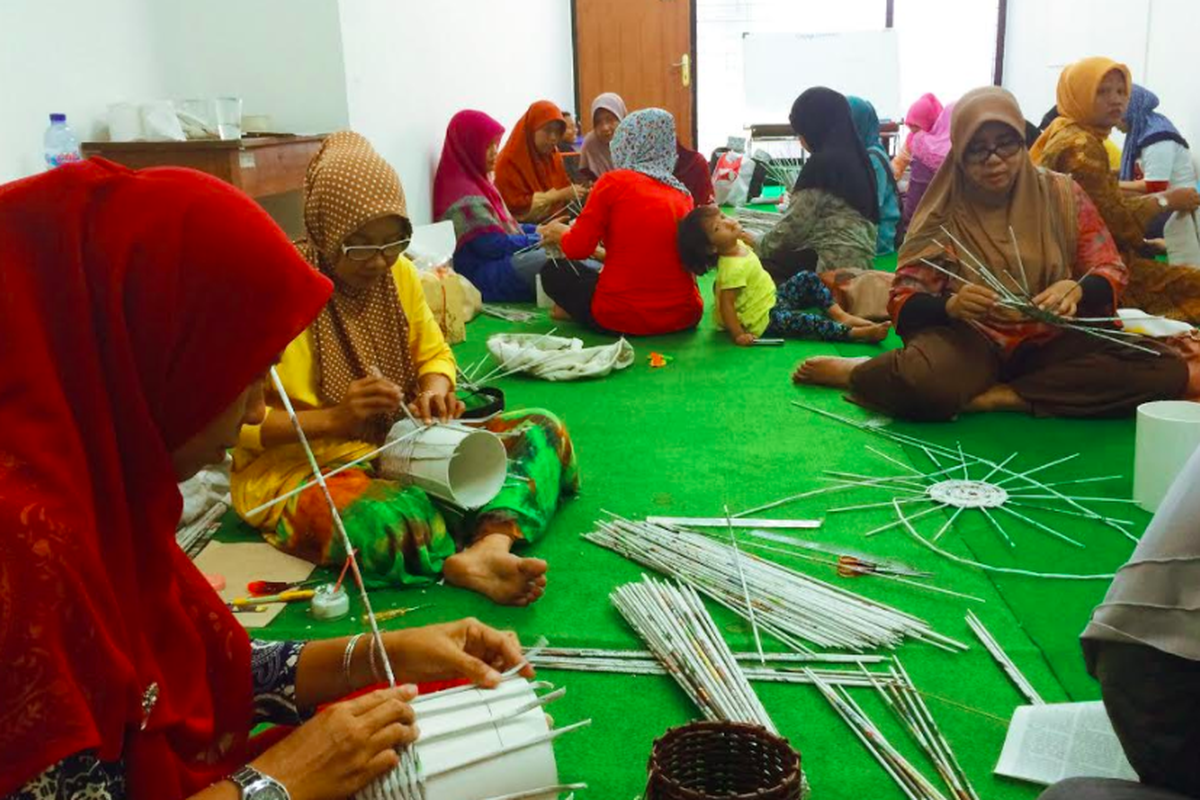 Sejumlah ibu warga Gelora tengah menganyam kerajinan dari koran di Rumah Kreasi.