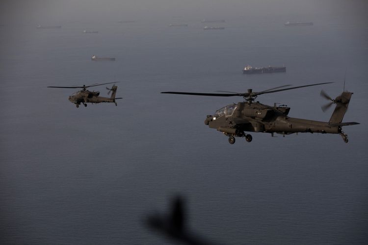 Helikopter Apache AH-64 terbang saat berpatroli di Selat Hormuz pada 17 April 2026, di tengah perang Iran melawan Amerika Serikat-Israel, yang berujung blokade jalur air strategis tersebut.