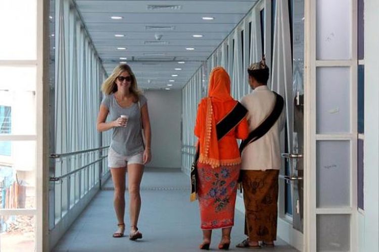 Cak dan Ning Kota Surabaya menyambut turis yang melintasi garbarata (jembatan penghubung kapal dan terminal) saat turun dari kapal pesiar MV Seabourn Odyssey yang singgah di Pelabuhan Tanjung Perak, Surabaya, Jawa Timur, Sabtu (29/11/2014).