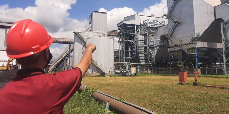 Seorang pegawai PT Industri Gula Glenmore (IGG) menunjukkan bagian boiler yang membakar limbah tebu hingga menghasilkan uap yang mendorong turbin listrik di pabrik mereka, di Desa Karang Harjo, Kecamatan Glenmore, Kabupaten Banyuwangi (2/7/2021)