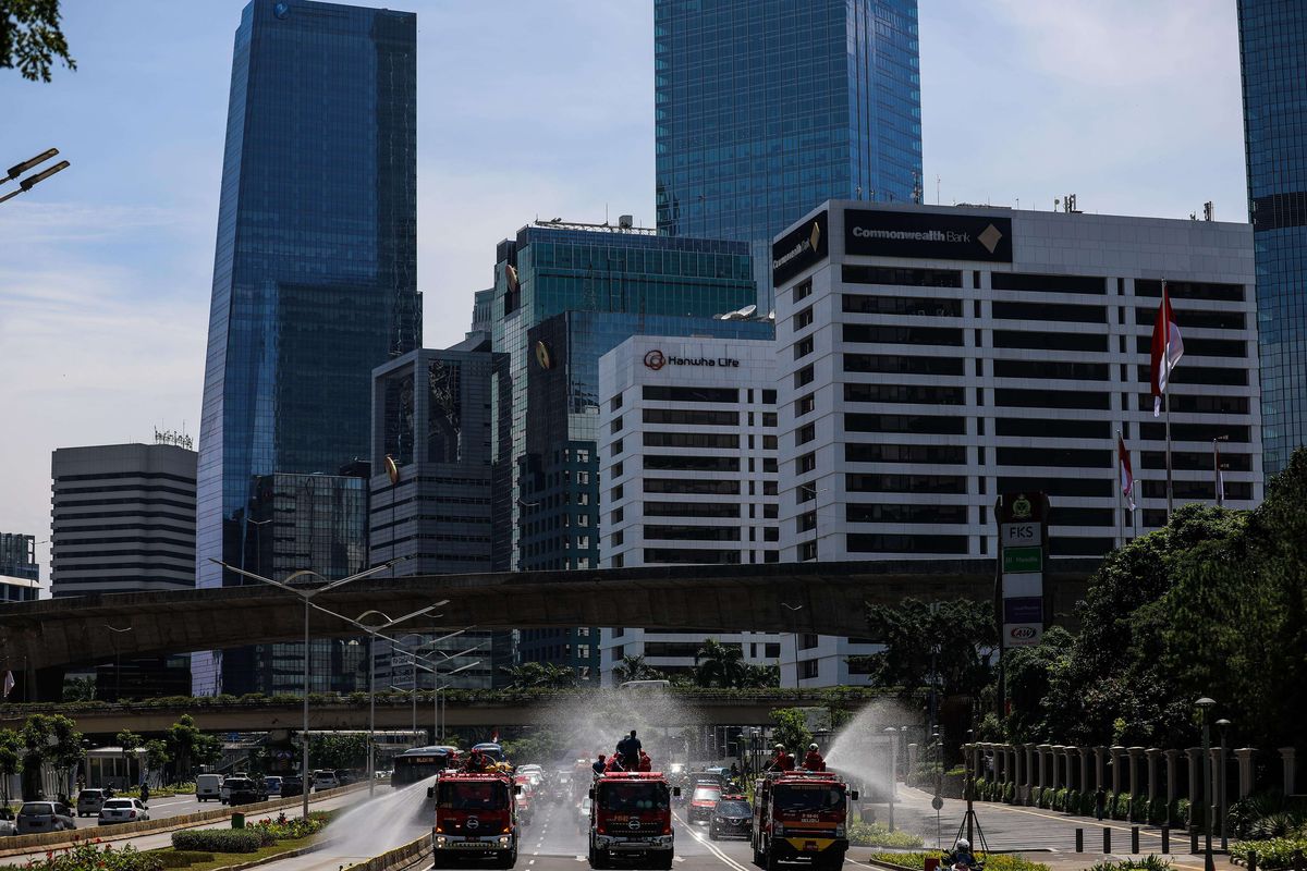 Petugas Pemadam Kebakaran (Damkar) menyemprotkan disinfektan di sepanjang jalan protokol dari monas sampai bunderan senayan di Jakarta, Selasa (31/3/2020). Penyemprotan disinfektan dalam rangka mitigasi pencegahan virus corona (COVID-19).