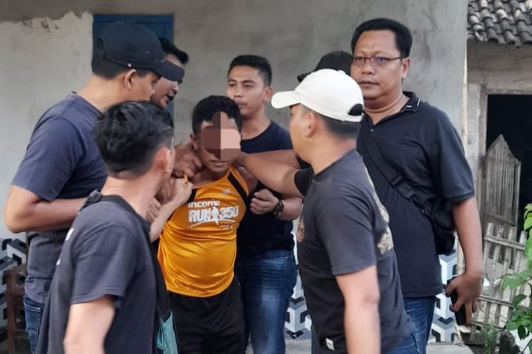 Petugas kepolisian saat menangkap SO (38), pelaku yang membunuh istrinya dan dibantu dua anaknya, di Kota Dumai, Riau, Senin (4/9/2023).