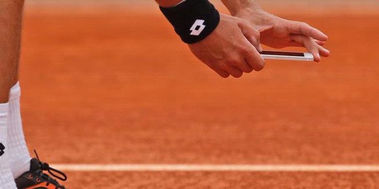 Petenis Ukraina, Sergiy Stakhovsky, memotret jejak bola dengan iPhone, karena tidak puas dengan keputusan wasit, saat melawan Richard Gasquet di babak pertama French Open, Senin (27/5/2013).