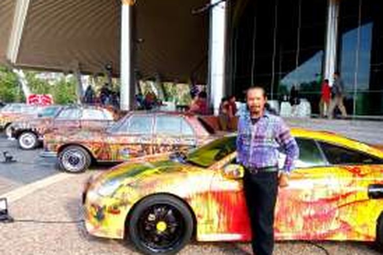 Nasirun berdiri di antara mobil-mobil yang menjadi media lukisannya. Atas karya-karyanya, seniman asal Bantul itu mendapatkan tiga penghargaan dari Museum Rekor Indonesia.