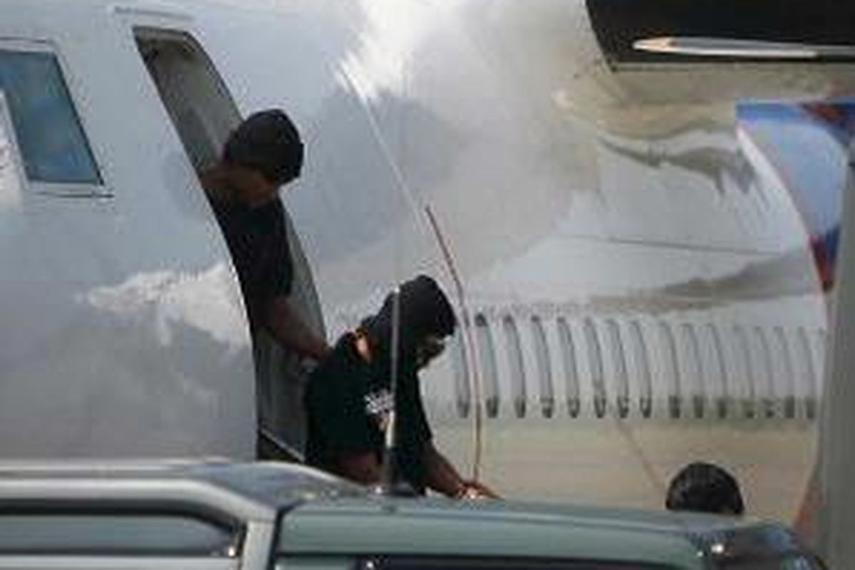 Tersangka Teroris Tiba di Jakarta - Personil Densus 88 Anti Teror membantu salah satu dari delapan tersangka teroris yang ditangkap di Palembang, sesampainya di Bandara Udara Halim Perdanakusuma, Jakarta, Kamis (3/7). Selanjutnya mereka dibawa ditahan Markas Komando Brimob, Kelapa Dua, Depok. 