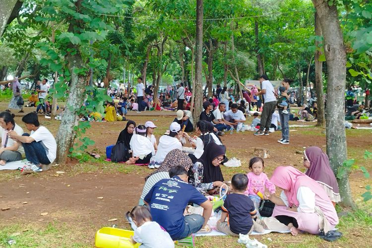 Sejumlah keluarga berpiknik di kawasan Monas saat libur awal tahun, Senin (1/1/2024).