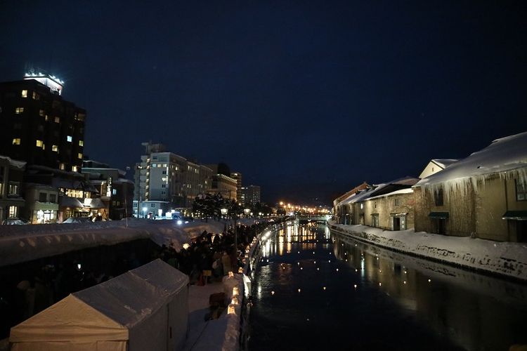 Wisatawan menikmati suasana malam di Otaru Canal, Kota Otaru, Prefektur Hokkaido, Jepang, Selasa (12/2/2019). Otaru Canal merupakan salah satu obyek wisata di Hokkaido yang menawarkan suasana malam di pinggir kanal buatan.