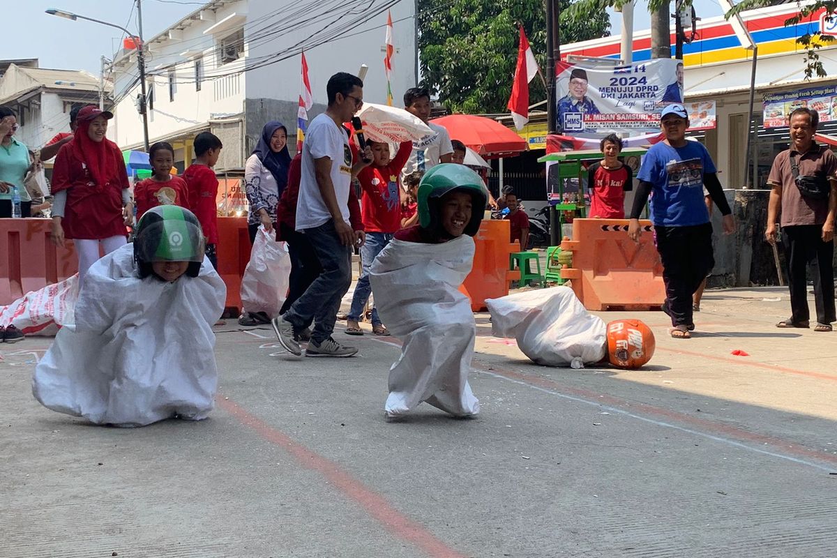 Warga Cipinang Melayu, Jakarta Timur, mengadakam perlombaan balap karung pakai helm ojol memperingati Hari Kemerdekaan Indonesia pada hari ini, Kamis (17/8/2023). 