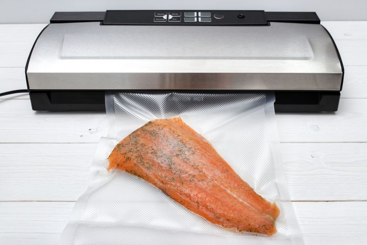 Ilustrasi menyegel makanan dengan vacuum sealer.